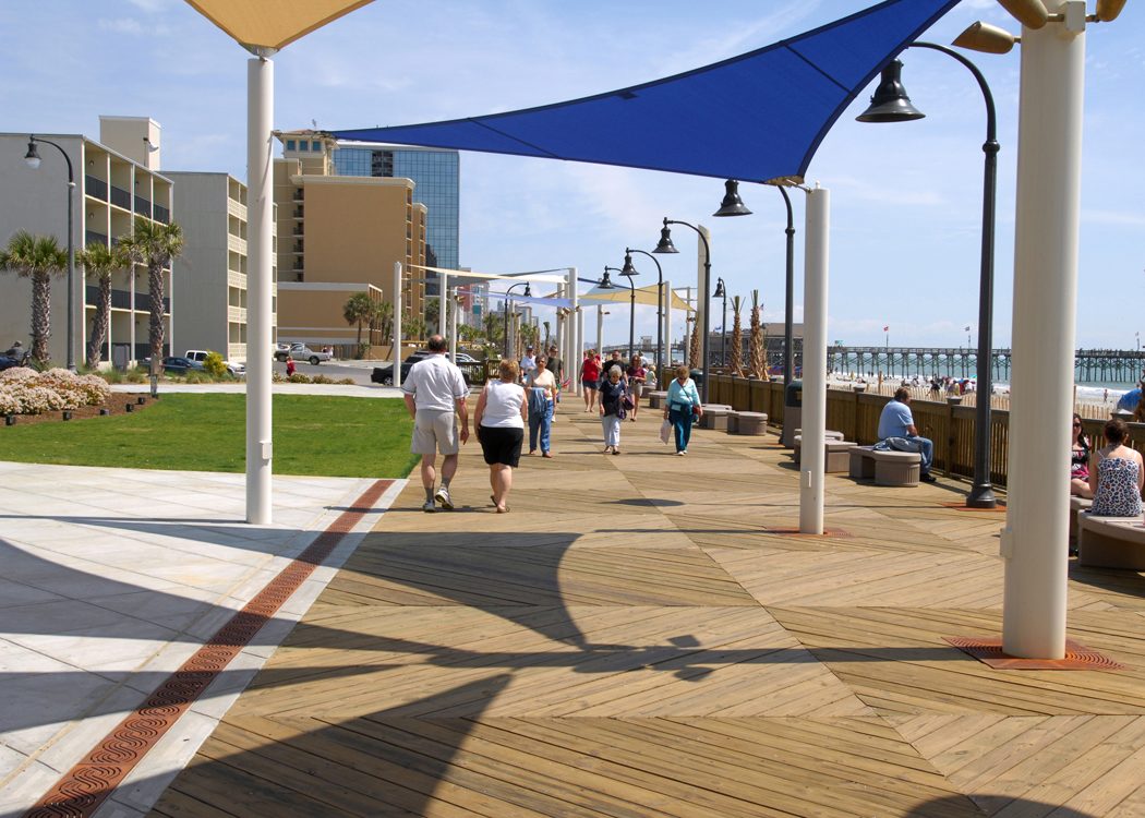 Visitors walking the wooden oceanfront boardwalk in Myrtle Beach